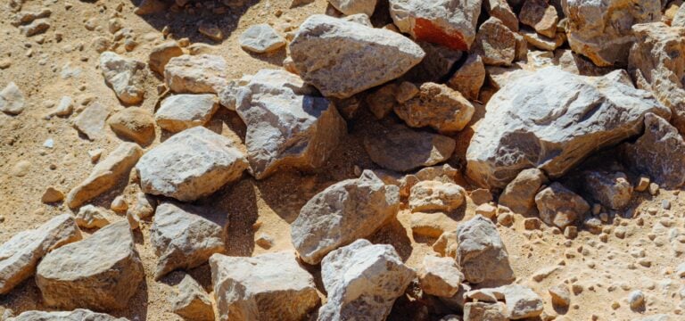 Rough stones scattered on the dusty ground in warm sunlight